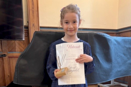 Foto: Musikschule Franziska Mellinghoff mit Silberner Stimmgabel und Urkunde als jüngste, punktbeste Teilnehmerin des Schulwettbewerbs 2025