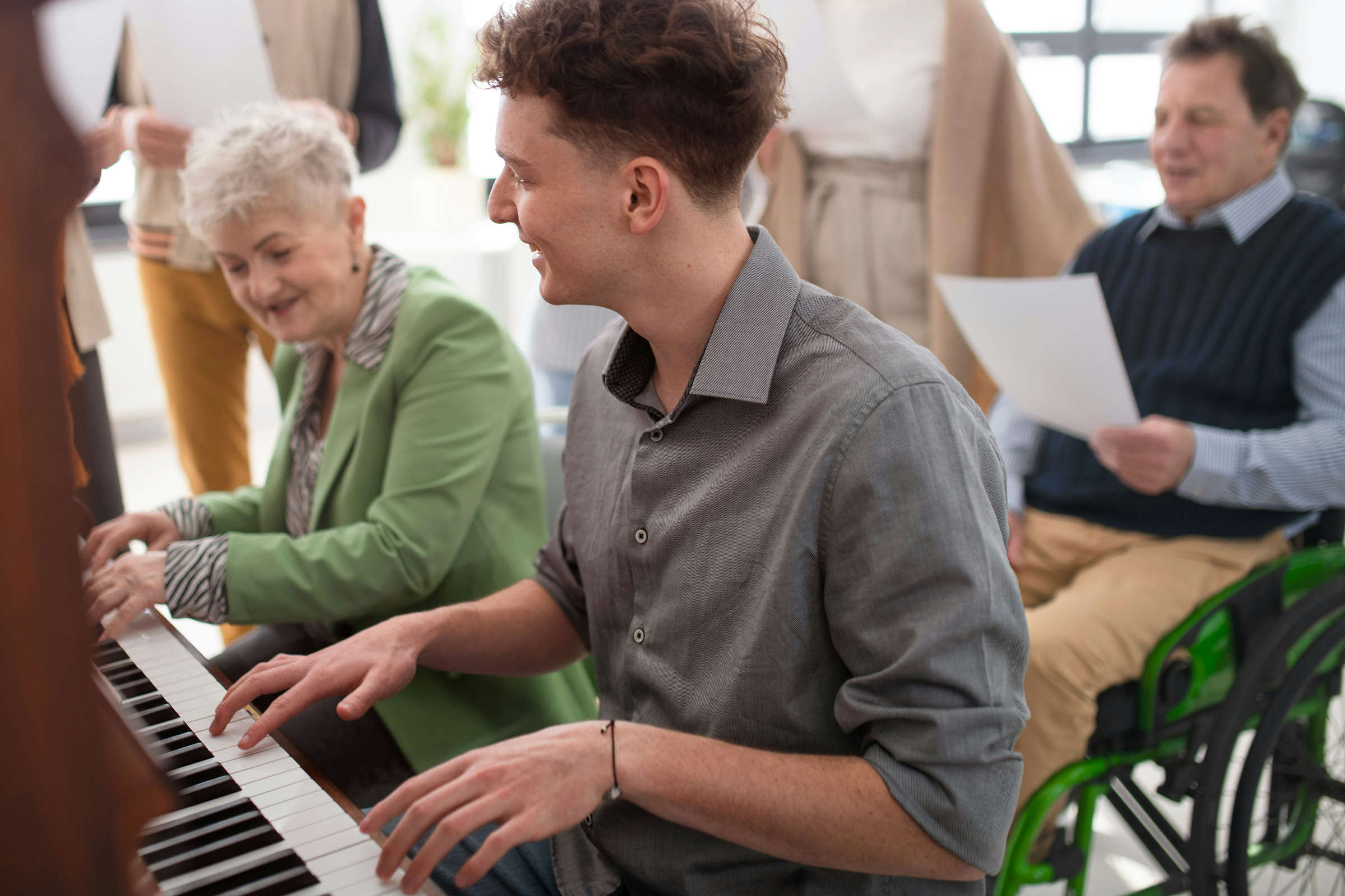 Foto: Getty Images/Unsplash.com junger Mann spielt mit ältere Dame zusammen am Klavier